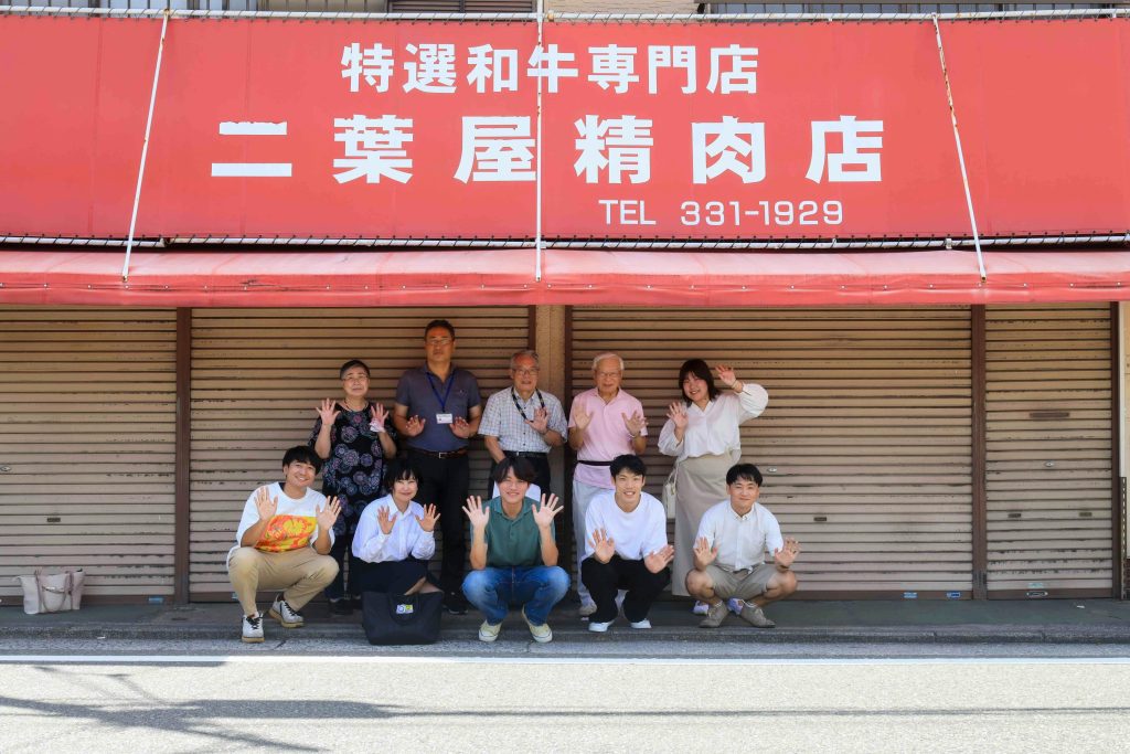 プロジェクト初期メンバーの当該建物前で集合写真